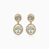 Gold drop earrings with diamond-encrusted circles and gray center stones