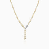 Pearl necklace with diamond-studded clasp, hanging against white background